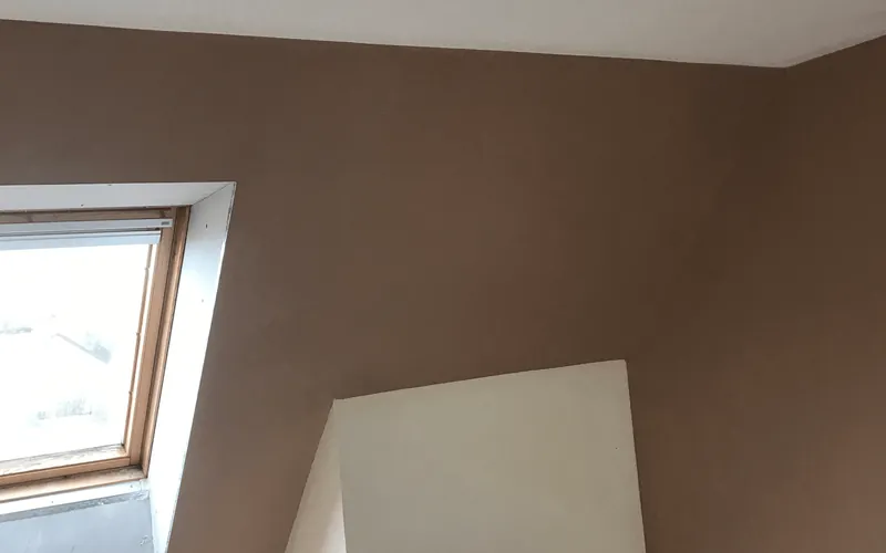 Sloping loft ceiling freshly skimmed around a roof window